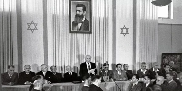 14 maja 1948 r. Premier Dawid Ben-Gurion ogłasza niepodległość Izraela. W tle portret Theodora Herzla. Ministerstwo Spraw Zagranicznych Izraela/Wikipedia, domena publiczna